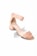 A stylish, peach-colored suede sandal with a block heel and ankle strap. The design features a unique scalloped edge on the strap, and the shoe has a modern, minimalist aesthetic.