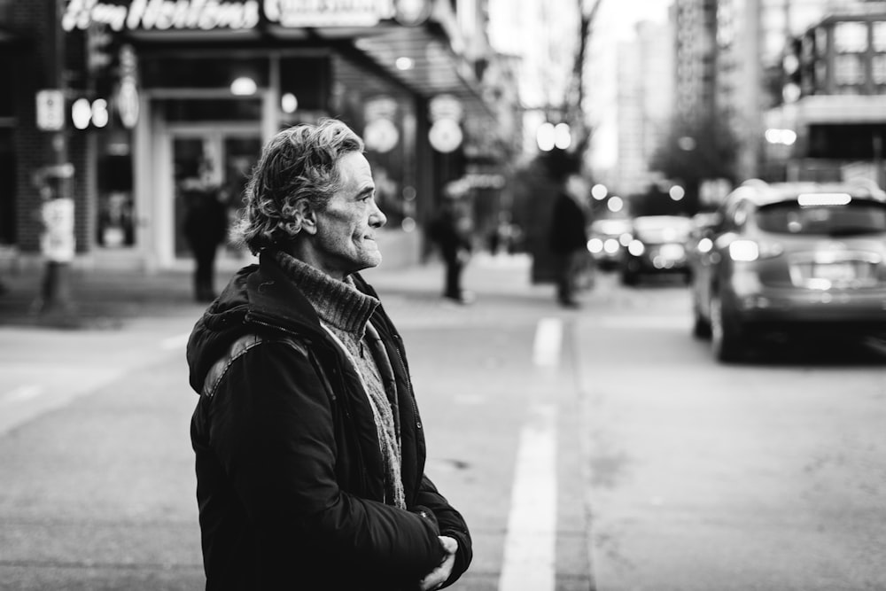 man in black jacket in front of the street