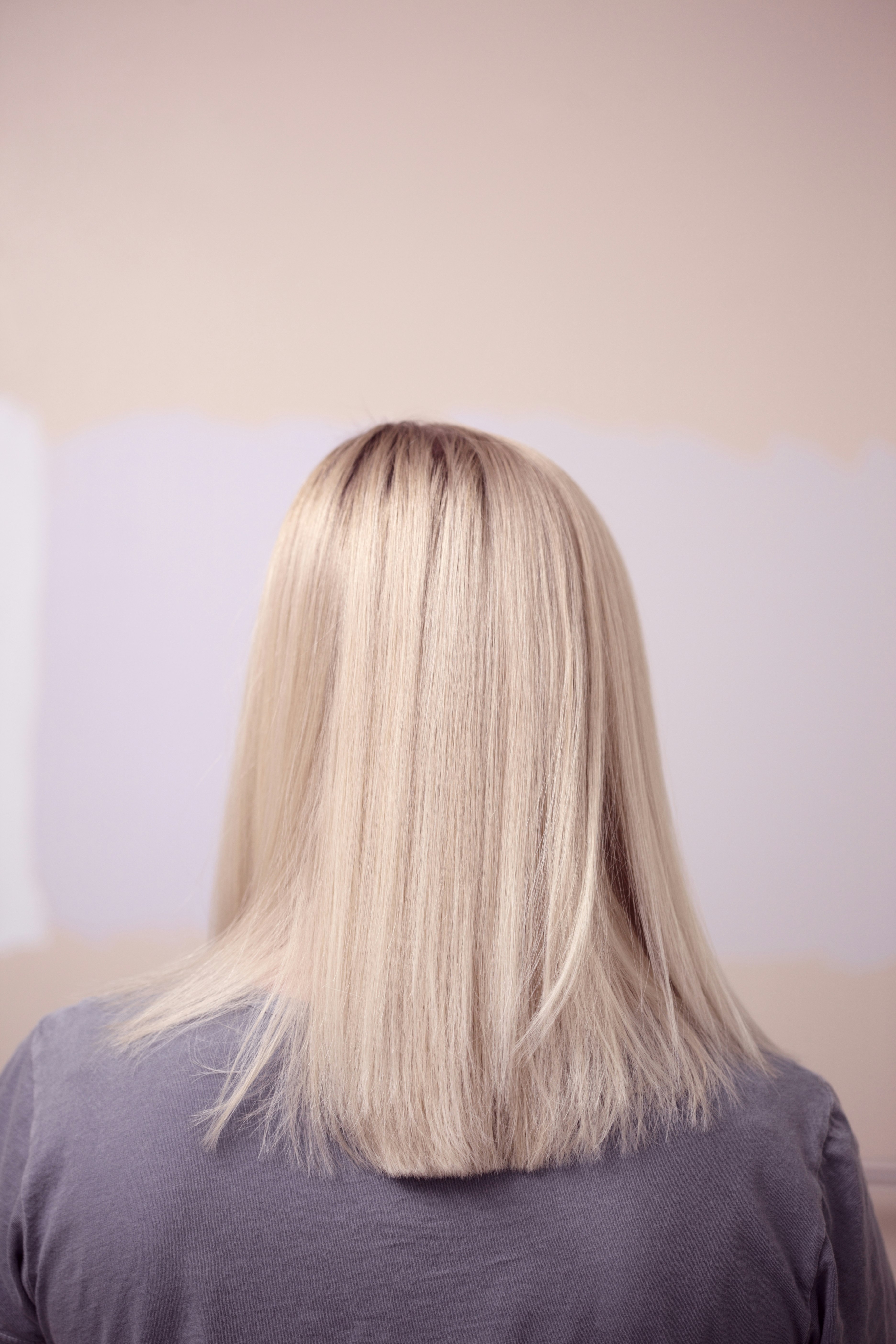 Portrait from behind of a young woman with lightened blonde hair.