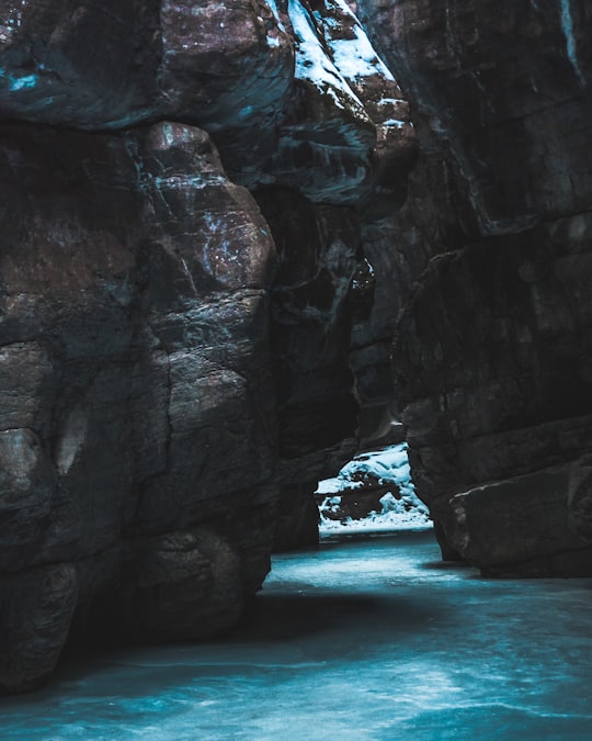 cave on body of water in Maligne Canyon Canada