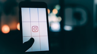 person using smartphone with Instagram logo screengrab bokeh photography