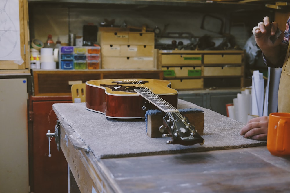 guitar resting on table near person in the kitchen