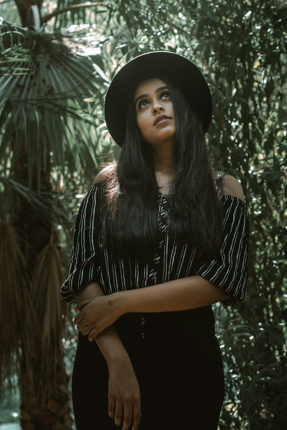 woman standing with green plants behind at daytime