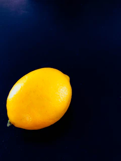 A golden lemon shining under soft light, illustrating the 'Auksinė citrina' package.