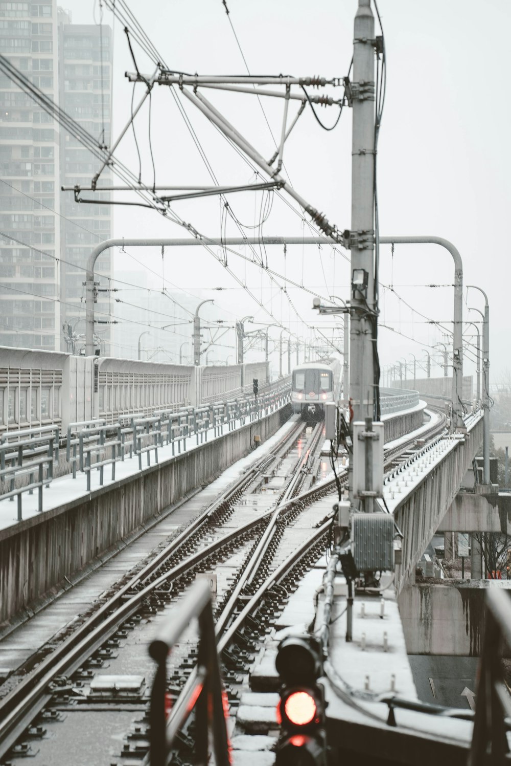 gray train on rail near glass building at daytime