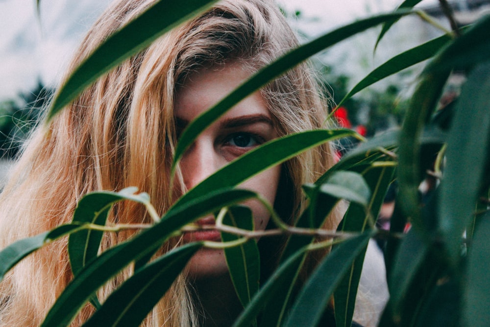 woman hiding behind plants