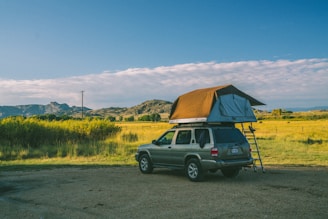 brown SUV parking with tent on top