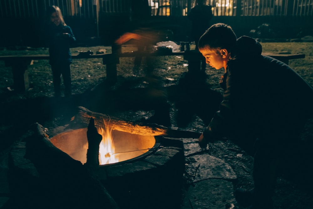 garçon tenant une barre en bois marron