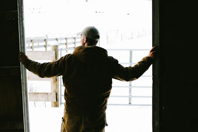 A warm handshake between a family insurance agent and a local farmer in a sunlit barn.