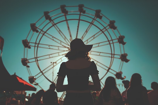 woman standing in front of ferris wheels surrounded with people in Arizona United States