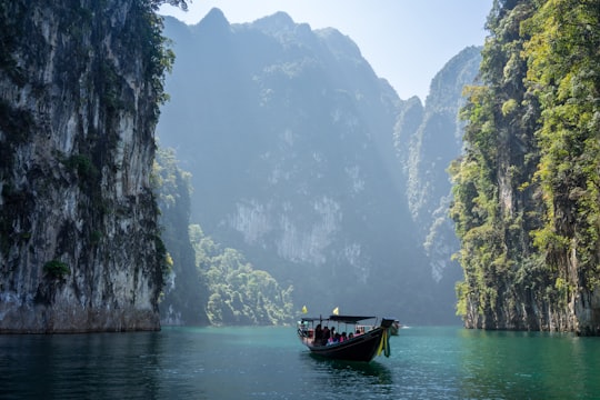 white boat in between rocky mountains in Khao Sok National Park Thailand