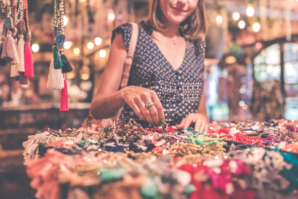 woman standing beside table of accessories