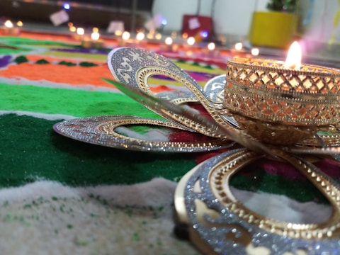 Close-up of a rustic metal candlestick with intricate scrollwork holding a lit candle.