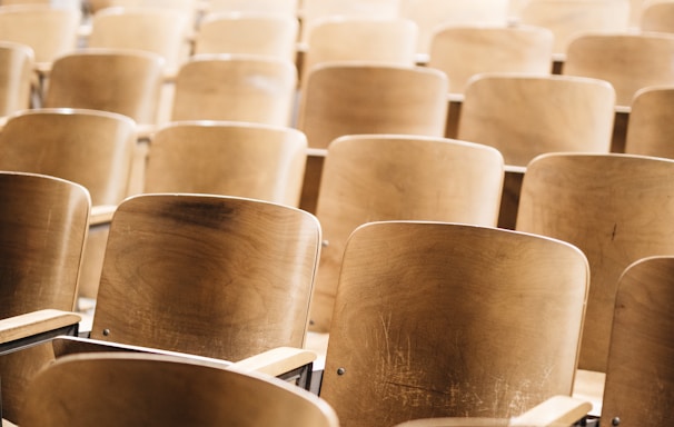 vacant brown wooden chair at stadium