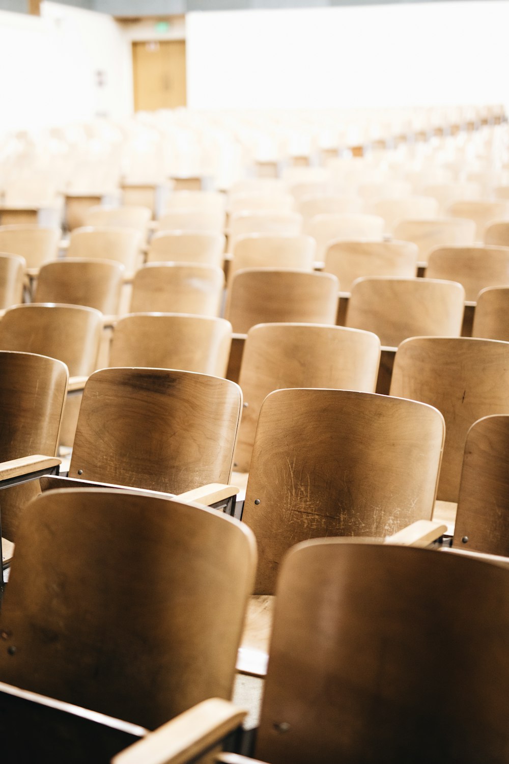 vacant brown wooden chair at stadium