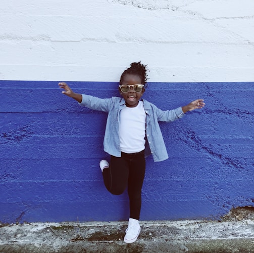 girl leaning on wall during daytime