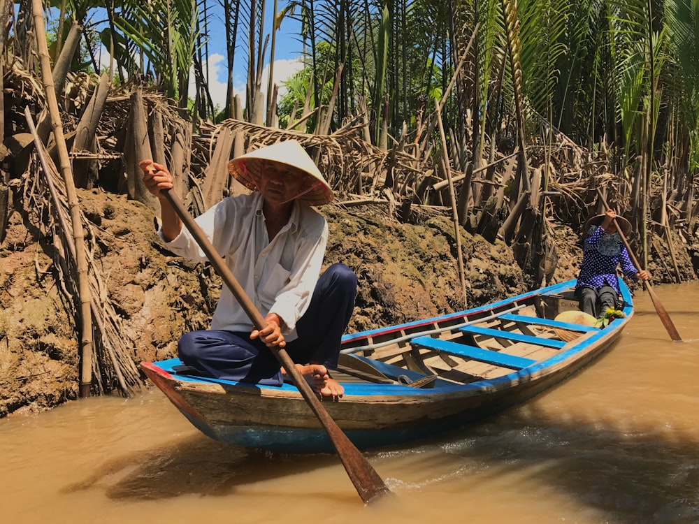 two men riding canoe on bridge