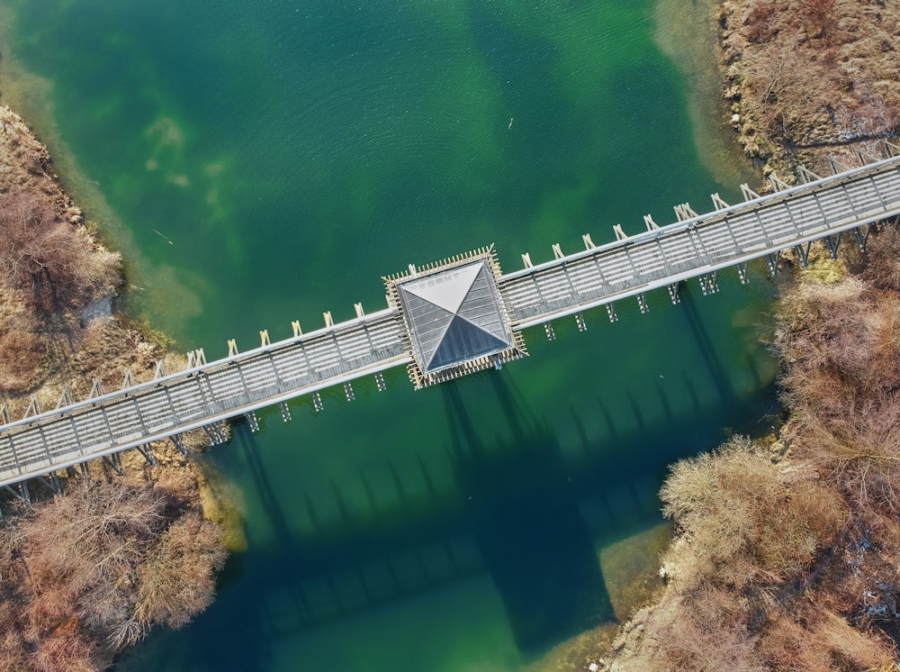 Photo d’angle supérieur d’un pont en béton gris au-dessus de l’eau verte prise de jour