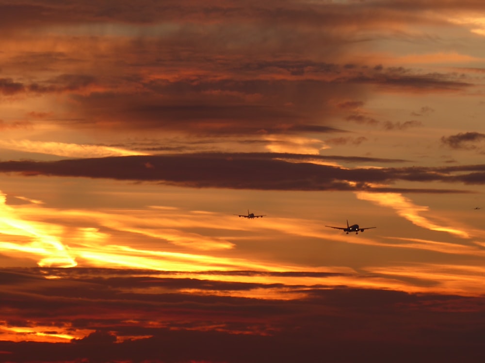 two aircraft at sky during sunset