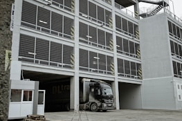 Friendly staff member assisting a truck driver at the parking entrance.