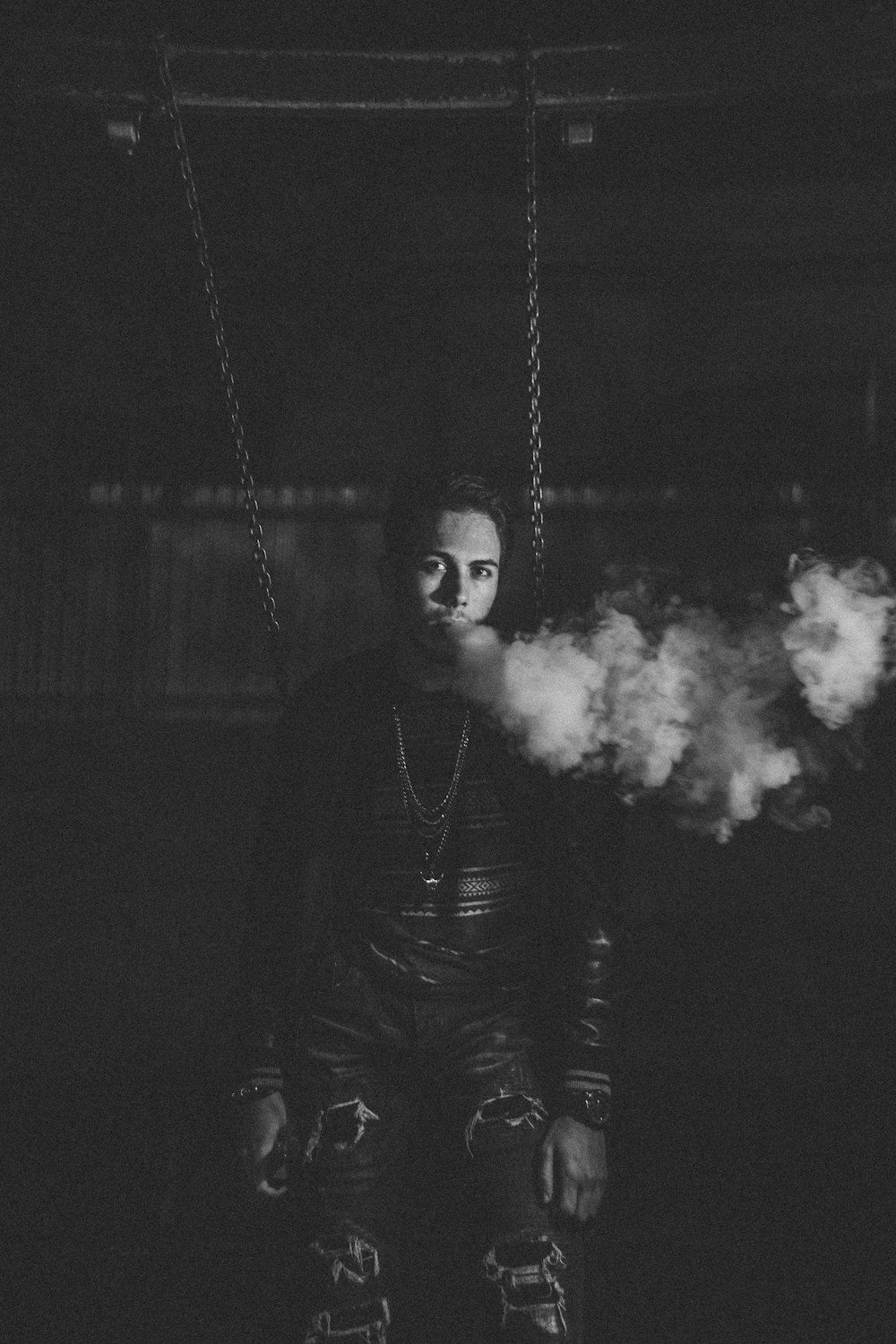 grayscale photography of man using vape