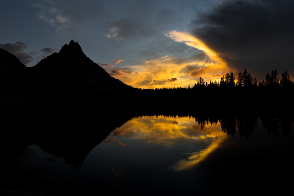 silhouette mountains and trees during golden hour