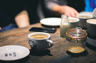 A cozy home setting with a phone and a cup of coffee on a wooden table