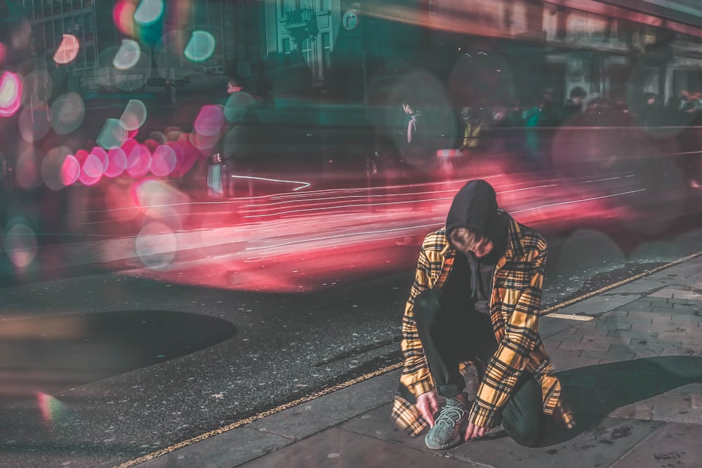 Mann schnürt Schuhe neben Straßen-Zeitrafferfotografie