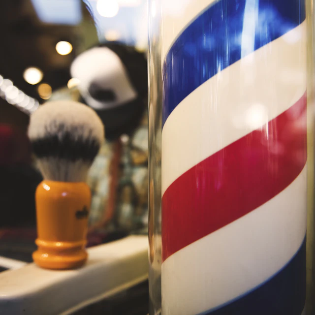 A red, white and blue spiral-striped barber pole outside a barbershop