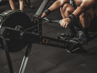 topless man using rowing machine