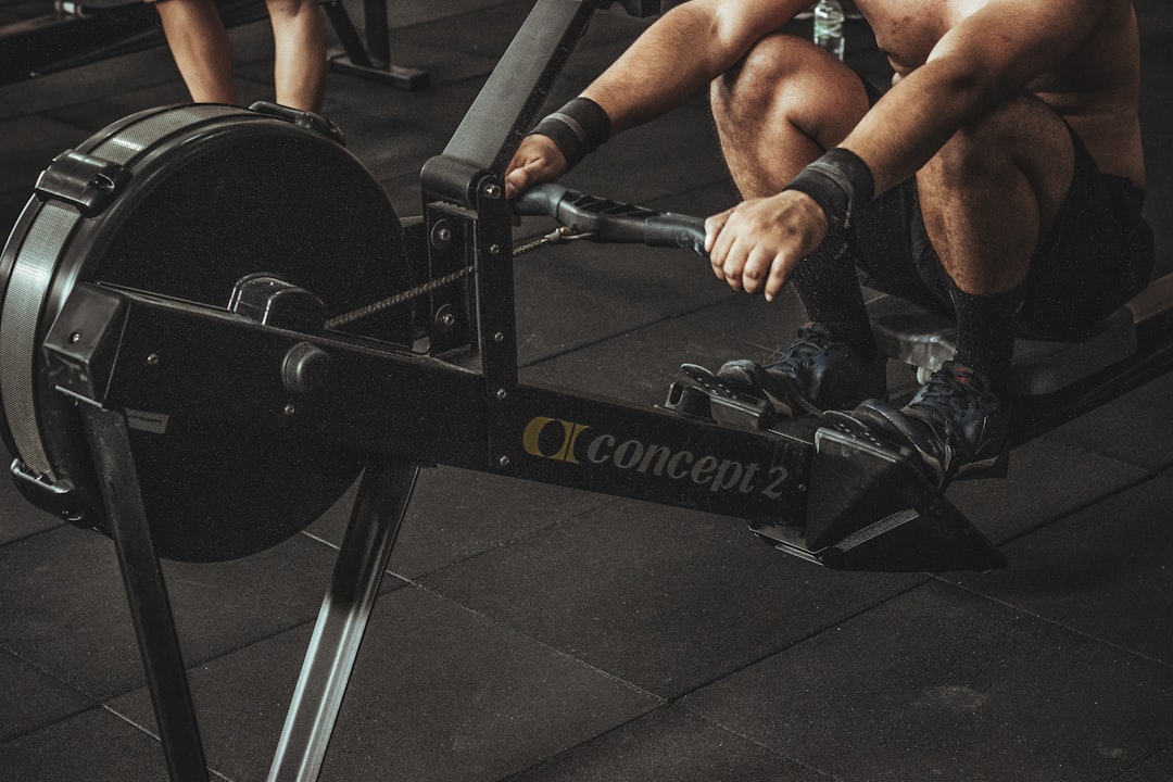 topless man using rowing machine,