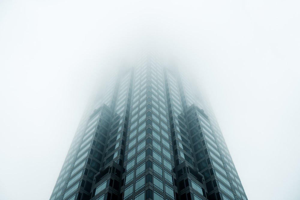 Immeuble de grande hauteur noir recouvert de brouillard
