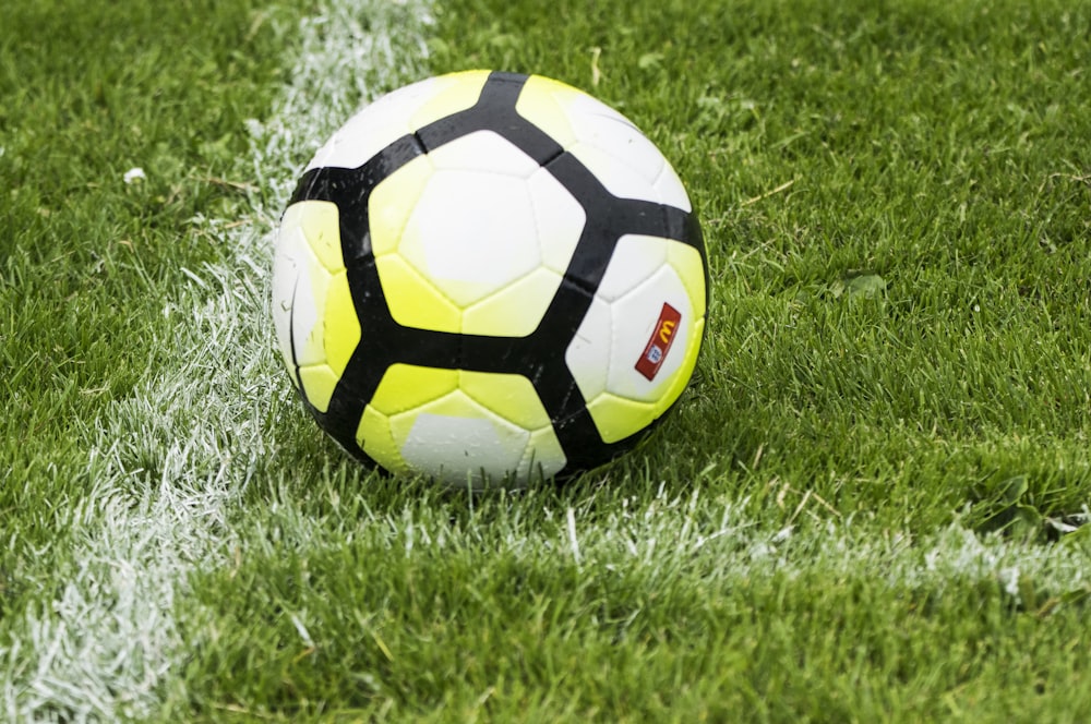 white and green soccer ball on green grass