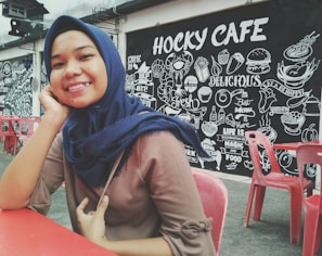 A smiling customer enjoying a freshly fried cheburek at a cozy Kaunas Cheburek table