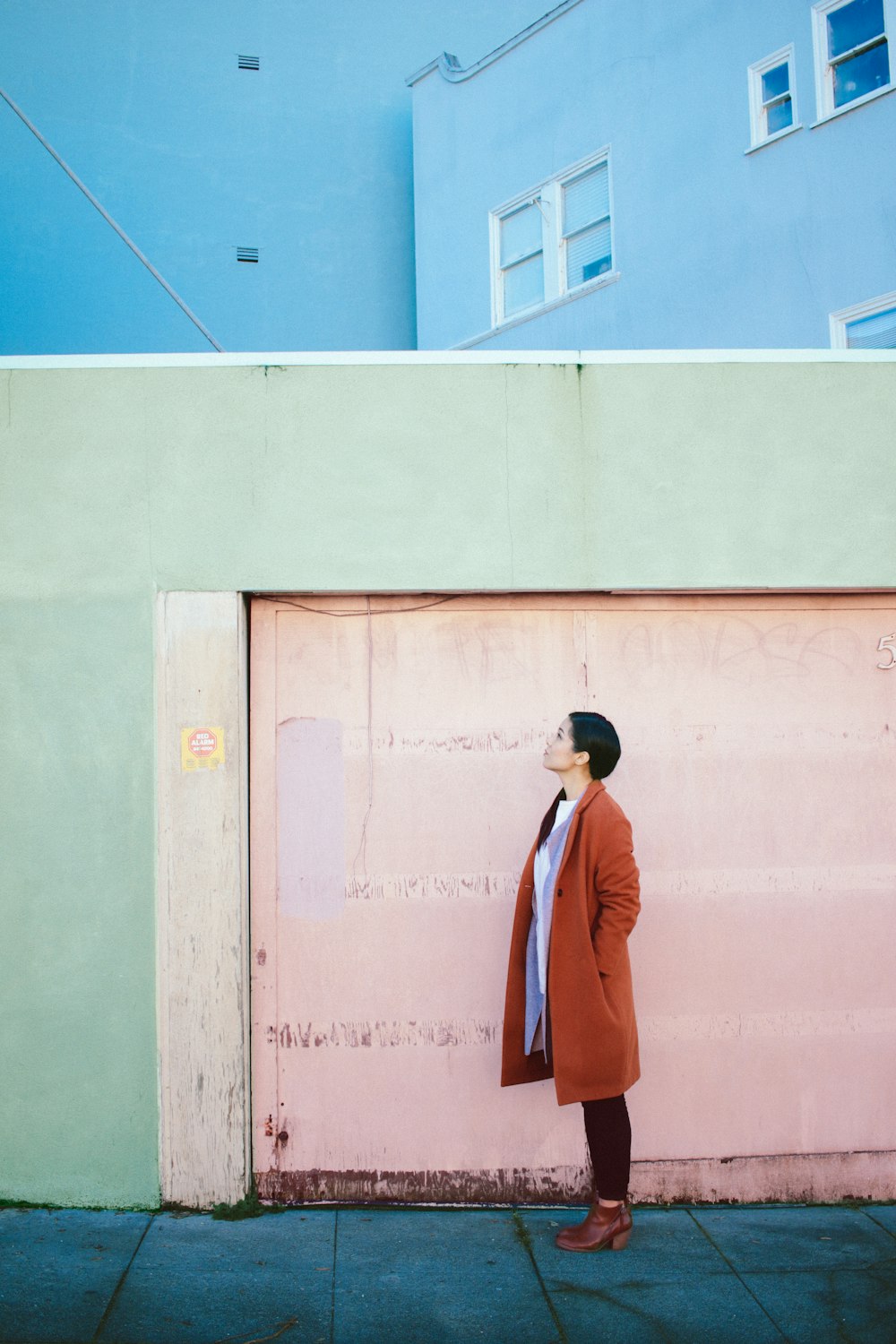 Mujer mirando hacia arriba frente a la puerta del garaje