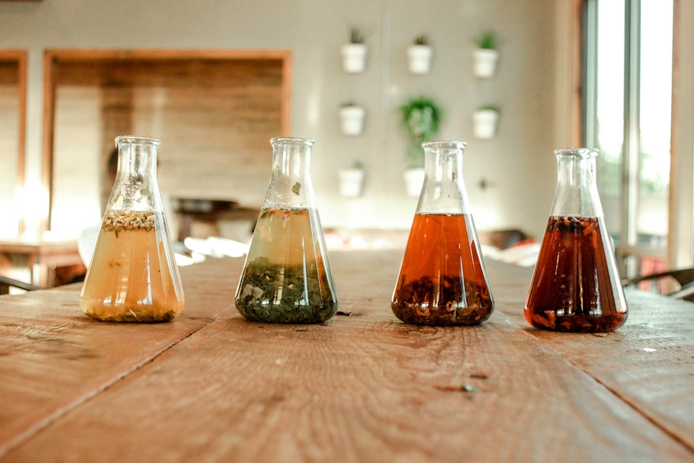 clear glass bottles on brown wooden table