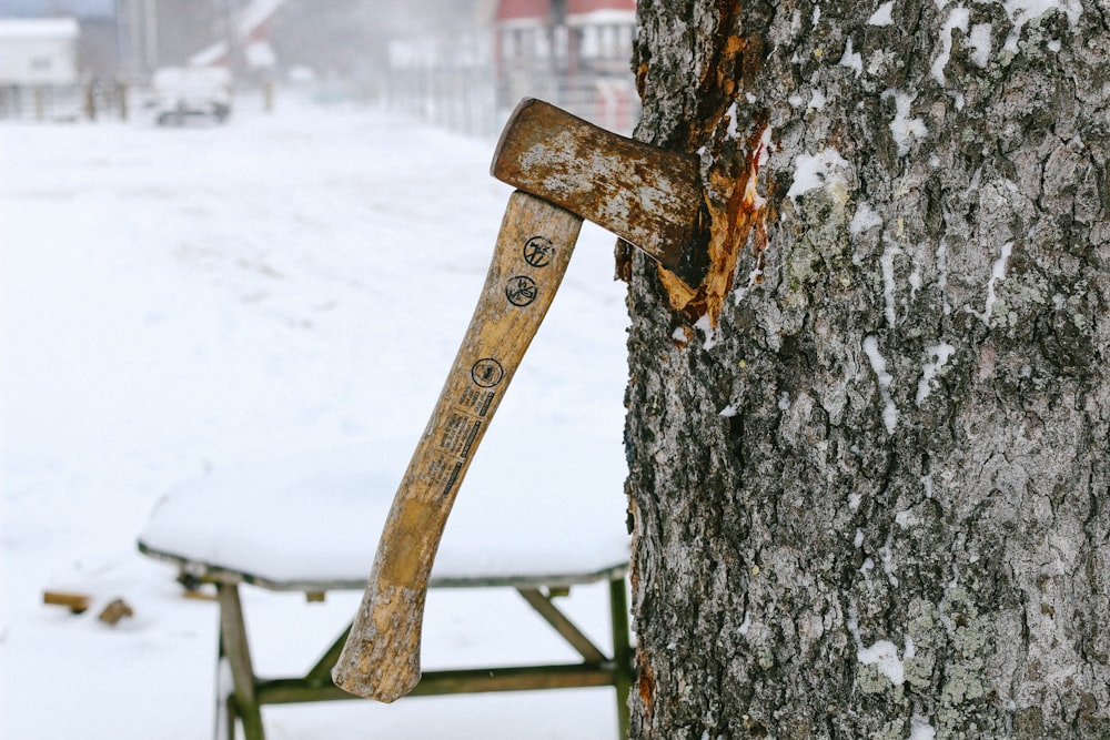 hacha clavada en el tronco de un árbol