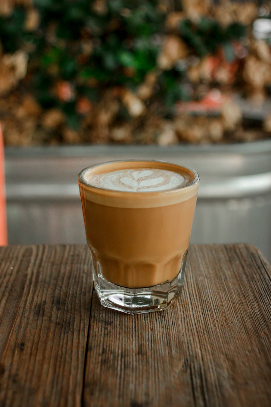 Cortado in a glass on a wooden table