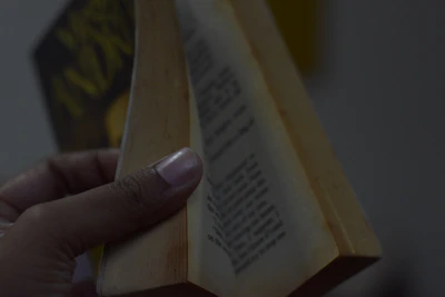Close-up of hands holding a book with a calming blue navy cover, symbolizing trust and expertise.