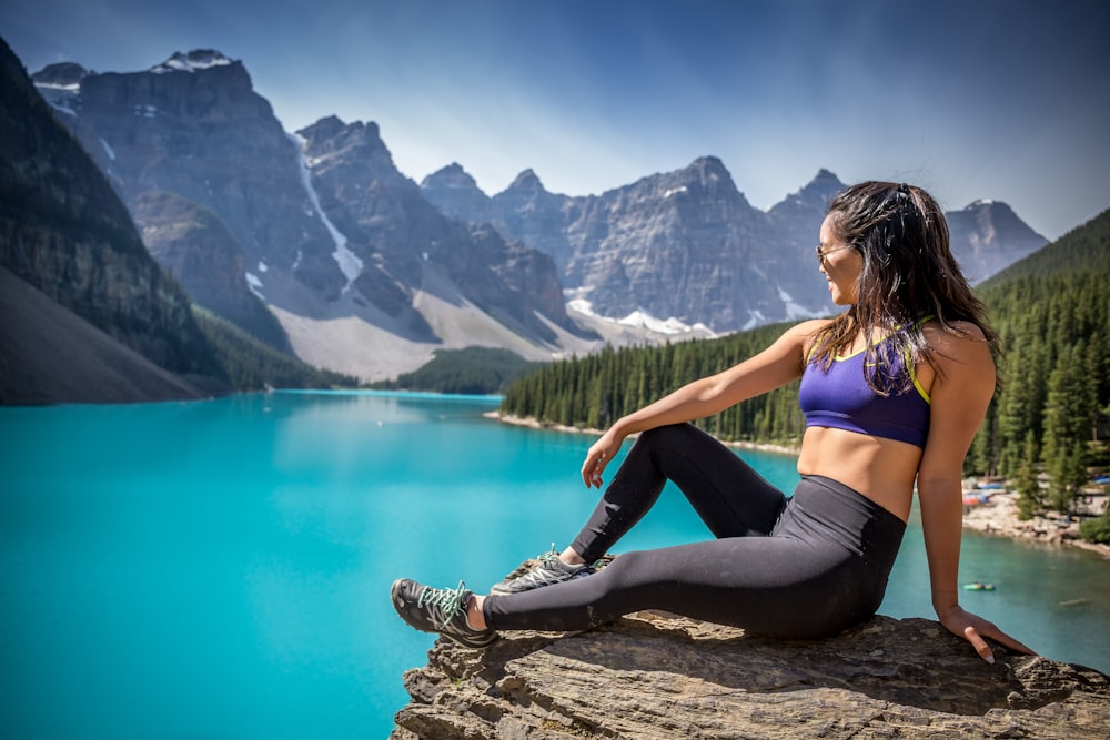 woman sitting on mountain cliff during daytime