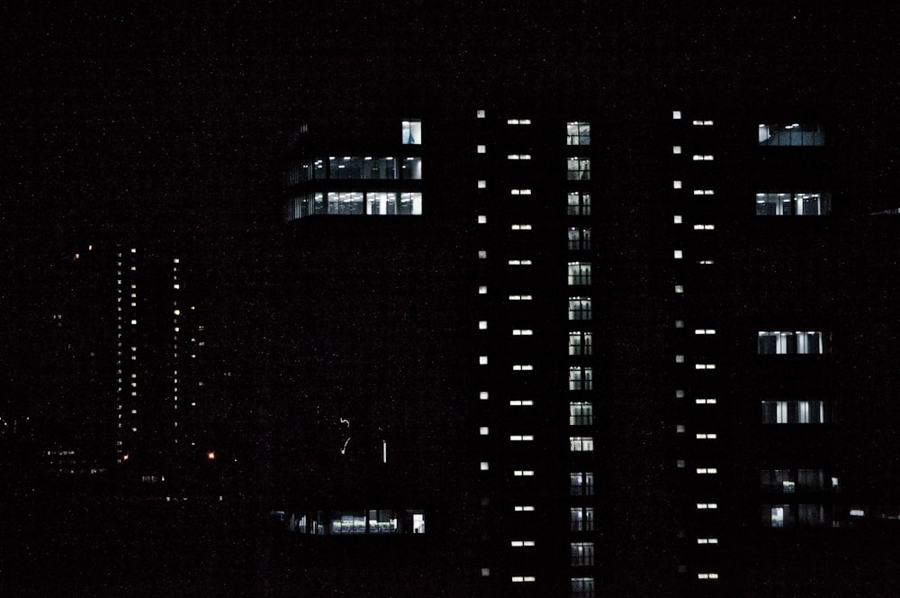 a very tall building with lots of windows lit up at night