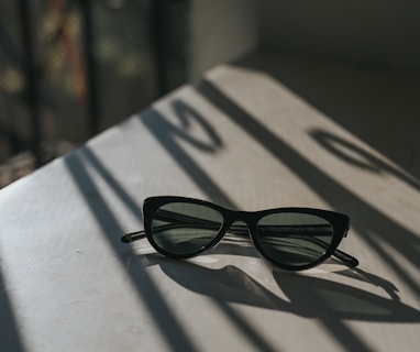 black framed sunglasses on white surface