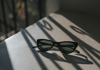 black framed sunglasses on white surface