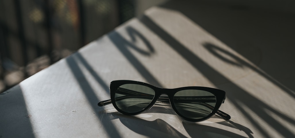 black framed sunglasses on white surface