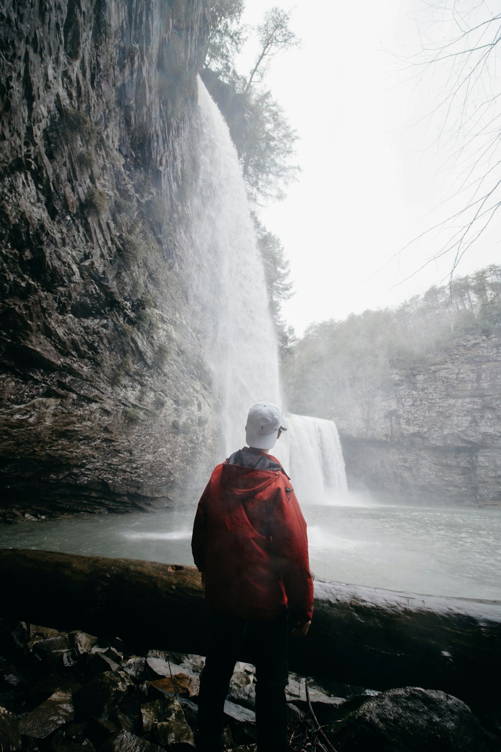 man standing in front of waterfalls