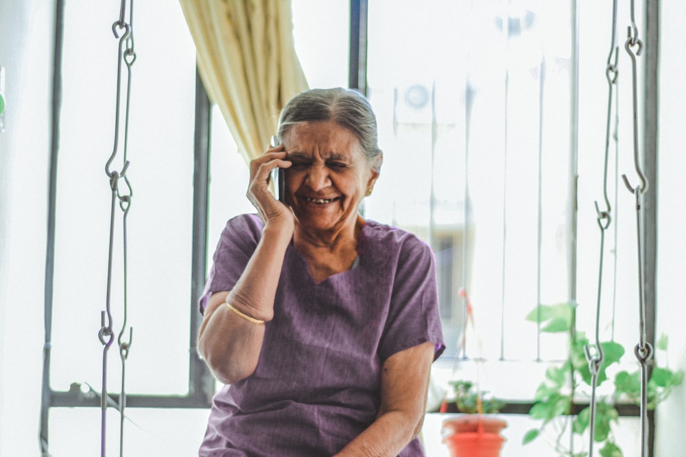 woman in purple V-neck top smiling while taking picture