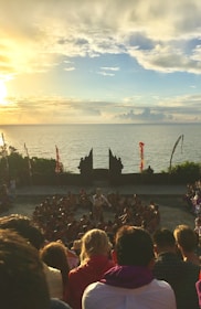 A serene group sitting in a circle outdoors, singing together at sunset.