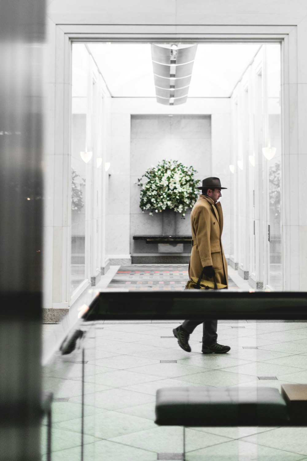 man holding brown bag while standing on hallway