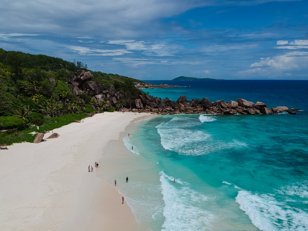 aerial view photography of seashore near mountain under cumulus clouds