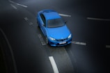 aerial photography of blue sedan on highway